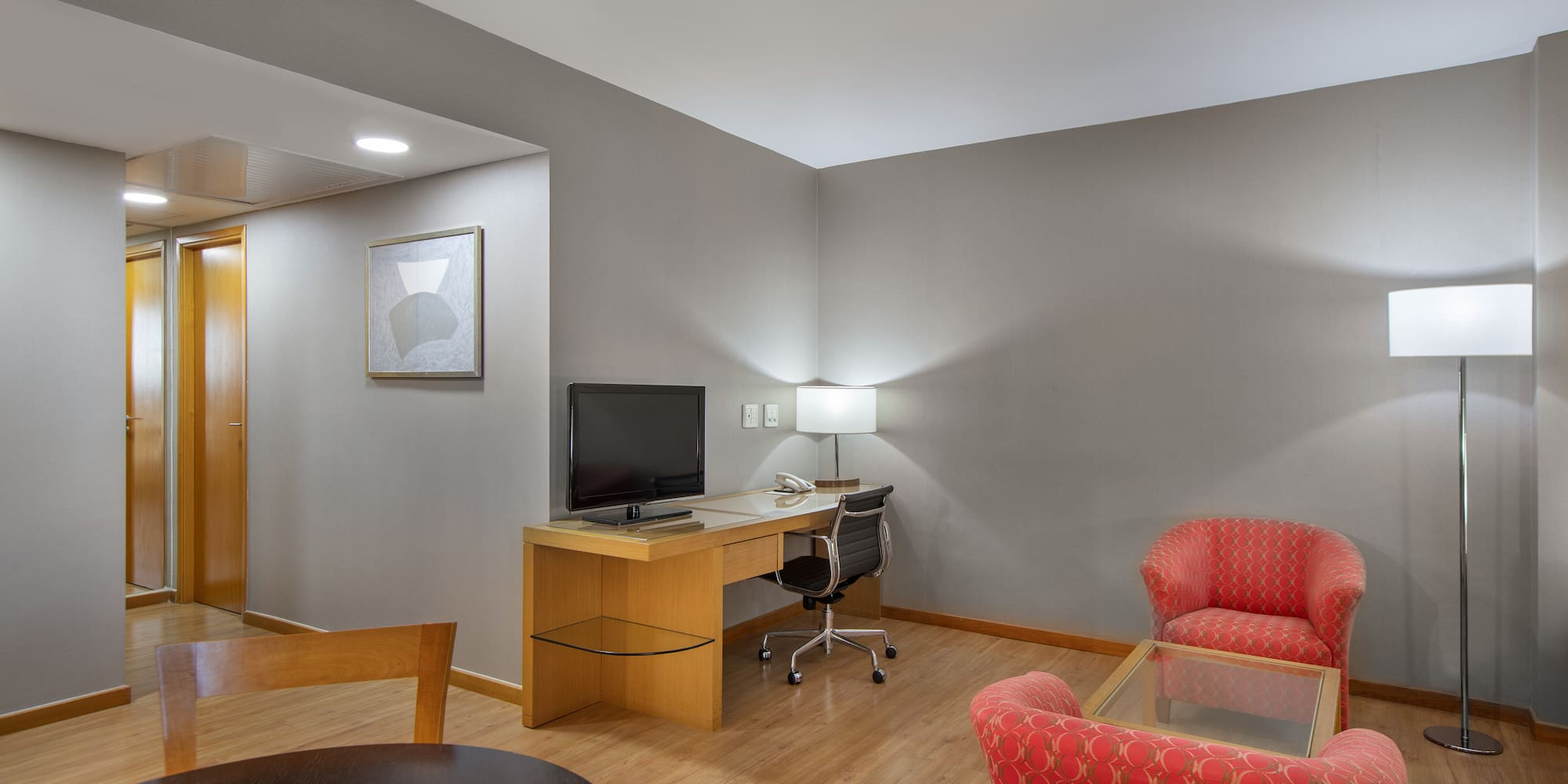 a room with a desk and chairs