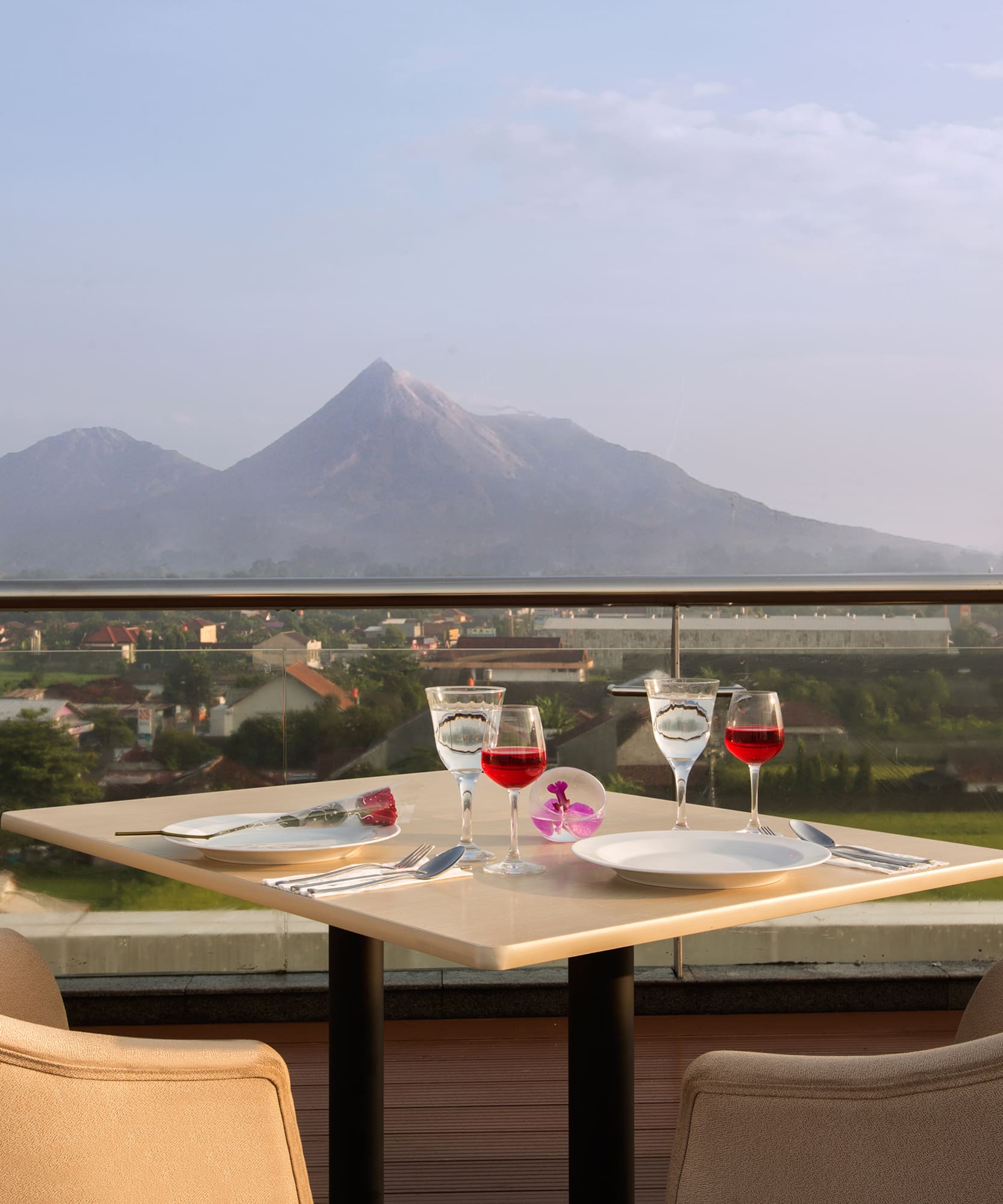 a table with wine glasses and a view of a mountain