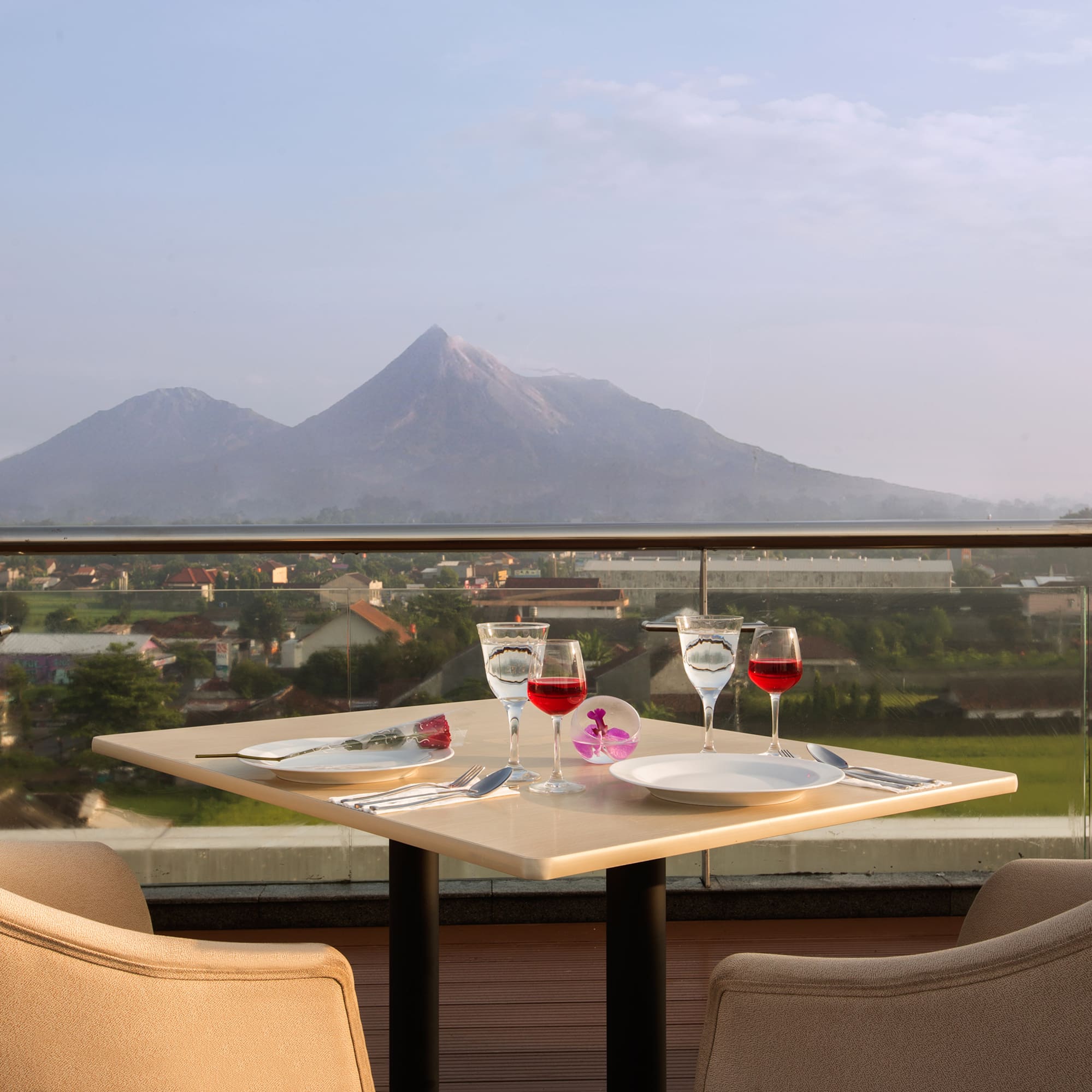 a table with wine glasses and a view of a mountain