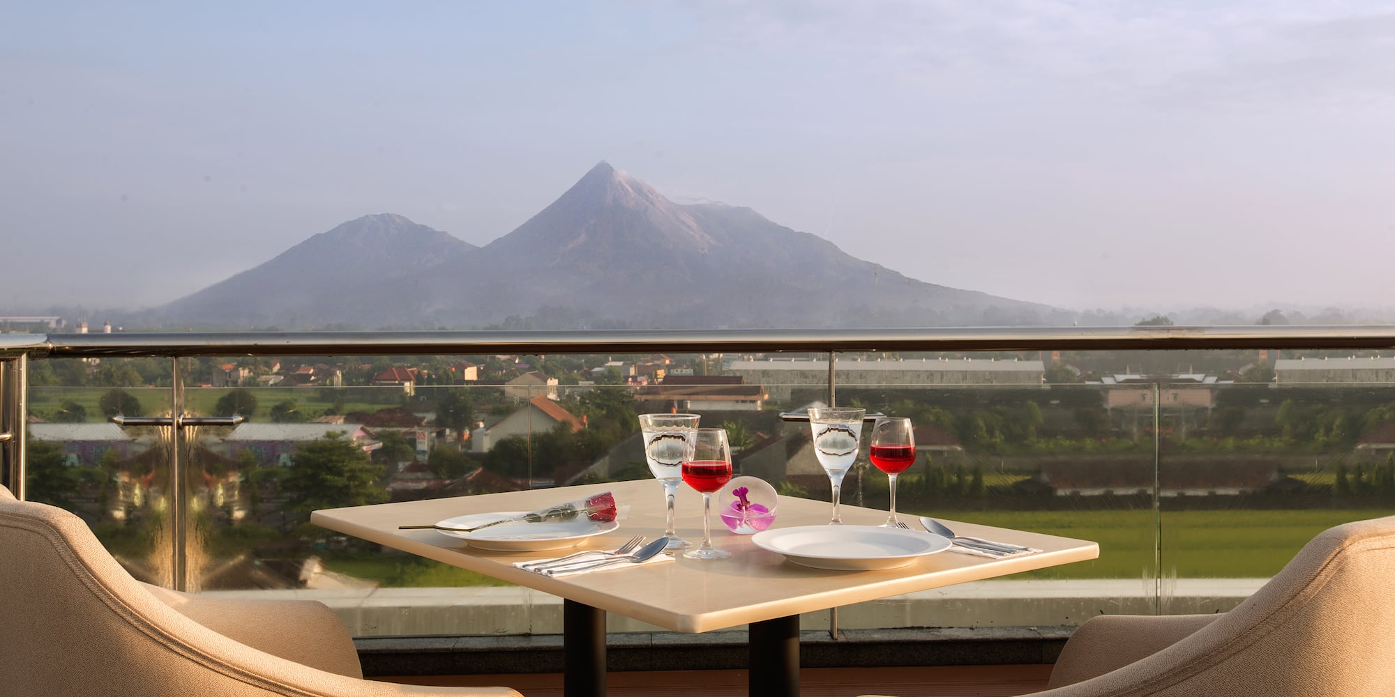 a table with wine glasses and a view of a mountain
