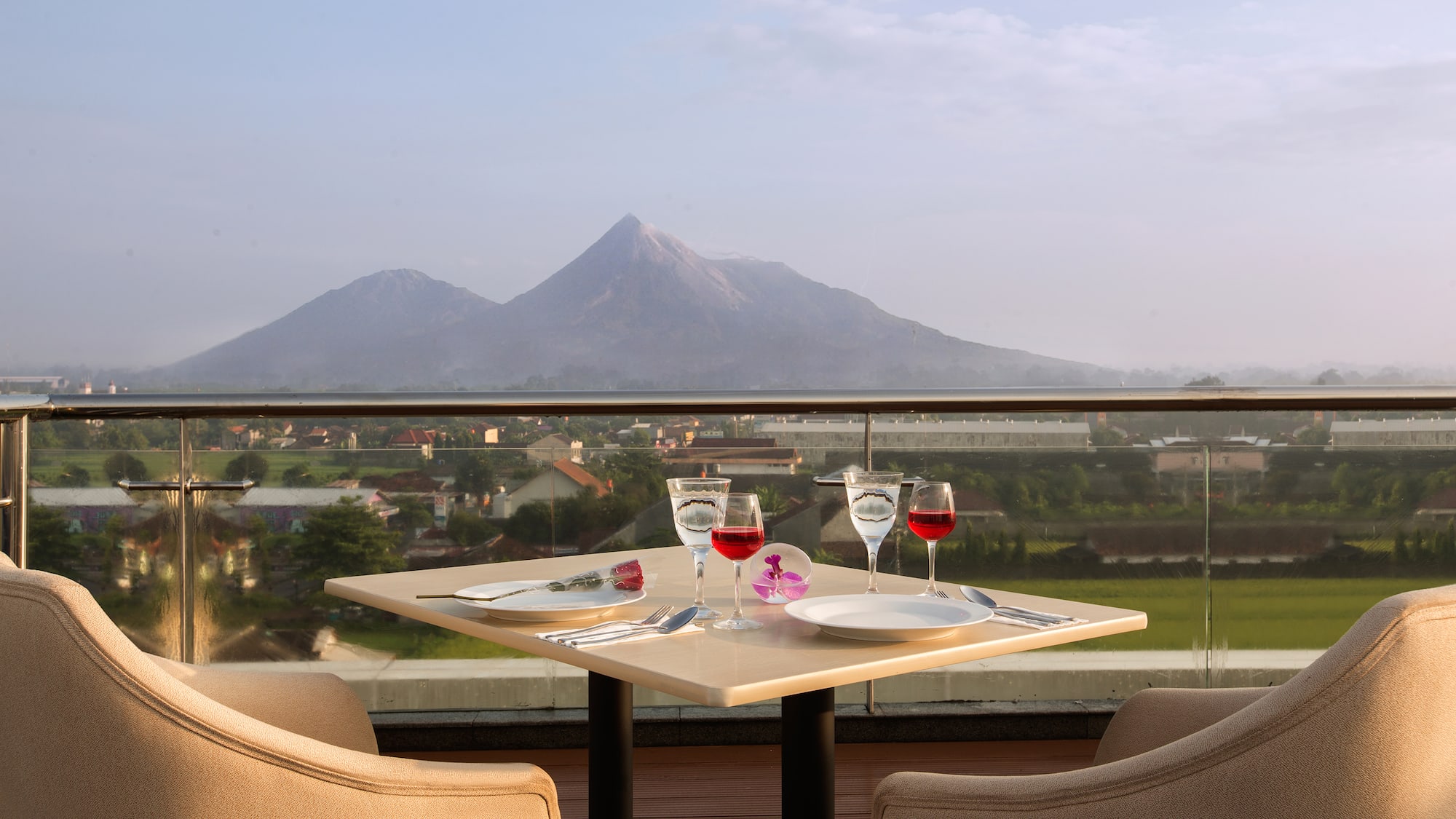 a table with wine glasses and a view of a mountain