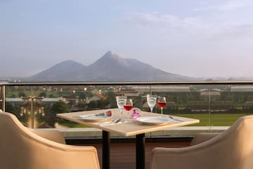 a table with wine glasses and a view of a mountain