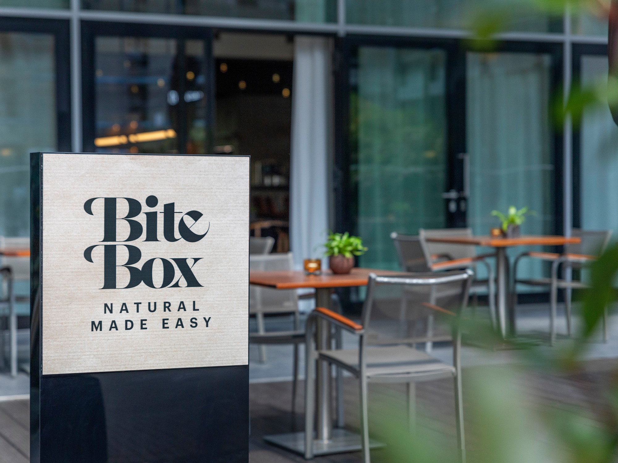 "Bite Box" cafe sign, "Natural Made Easy", with outdoor patio seating.