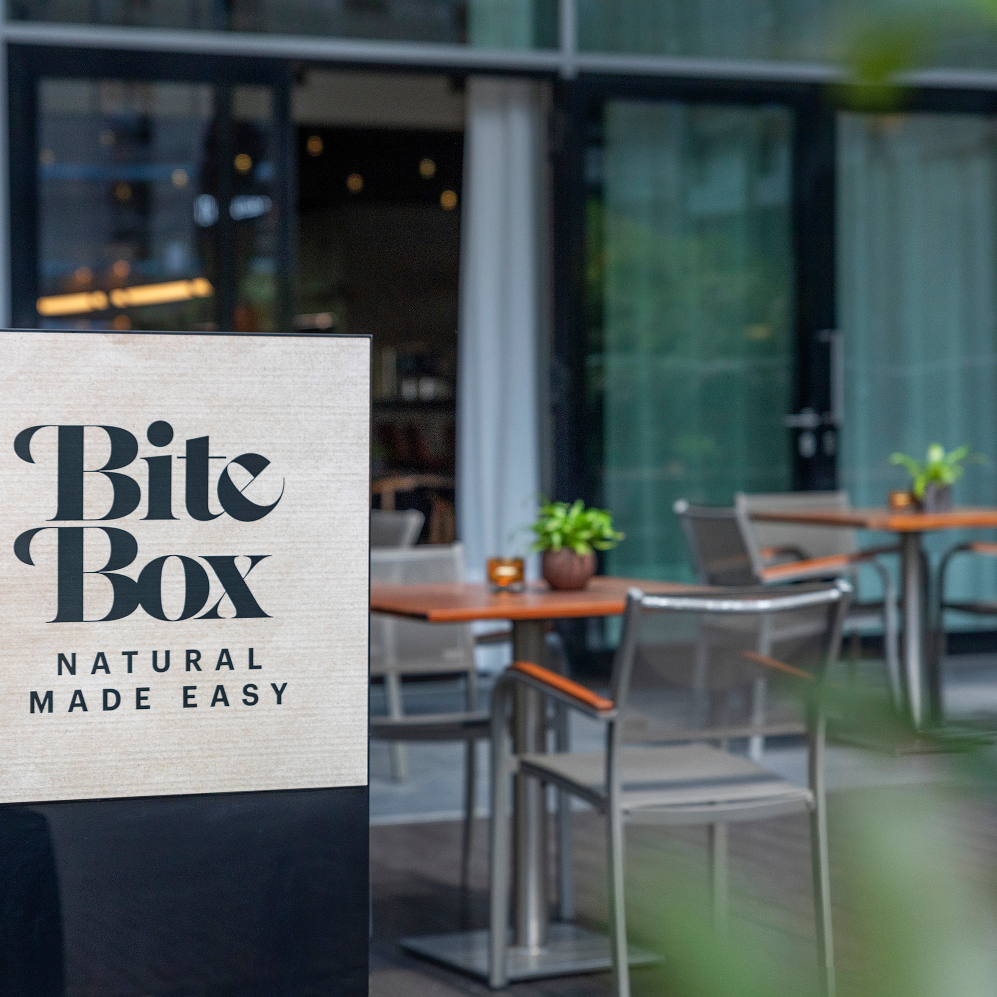 "Bite Box" cafe sign, "Natural Made Easy", with outdoor patio seating.