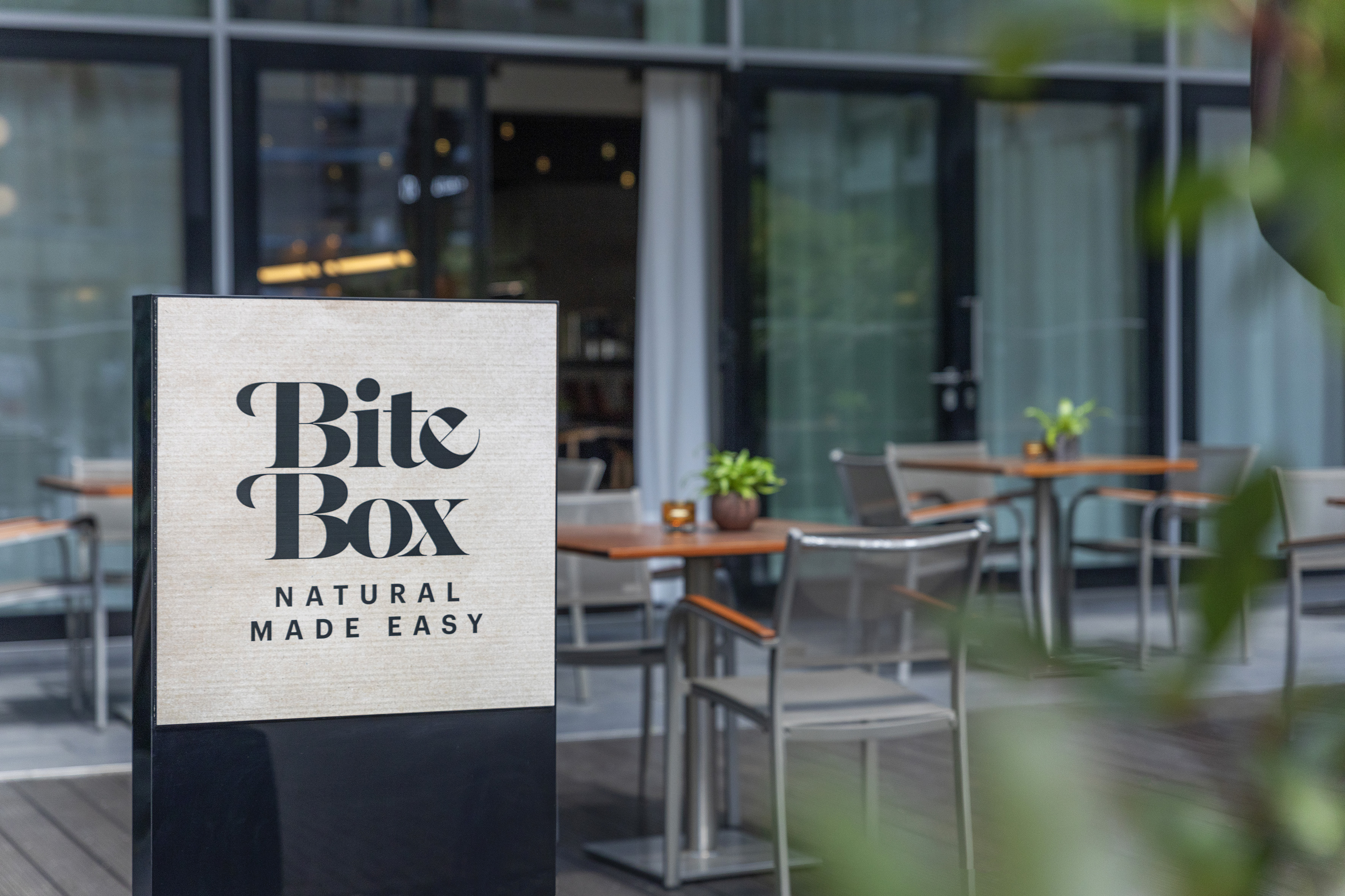 "Bite Box" cafe sign, "Natural Made Easy", with outdoor patio seating.