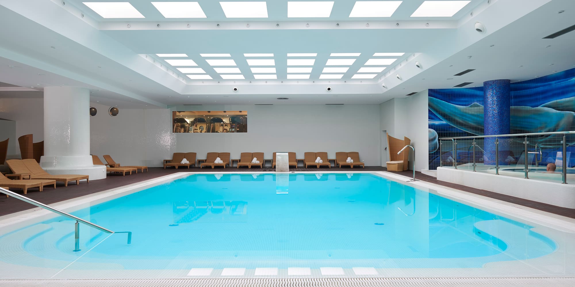 a swimming pool with chairs and a deck.