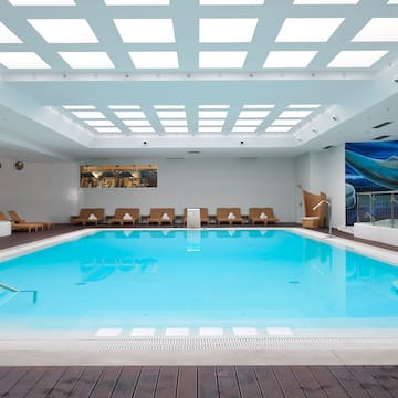 a swimming pool with chairs and a deck.
