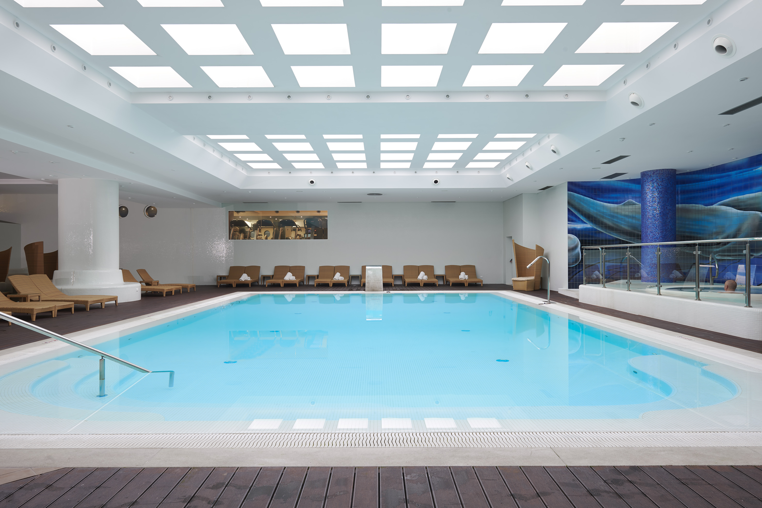 a swimming pool with chairs and a deck.