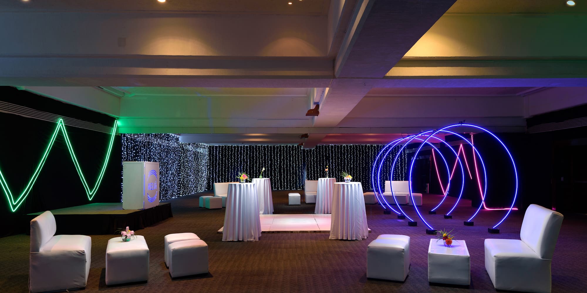 a room with white tables and blue lights