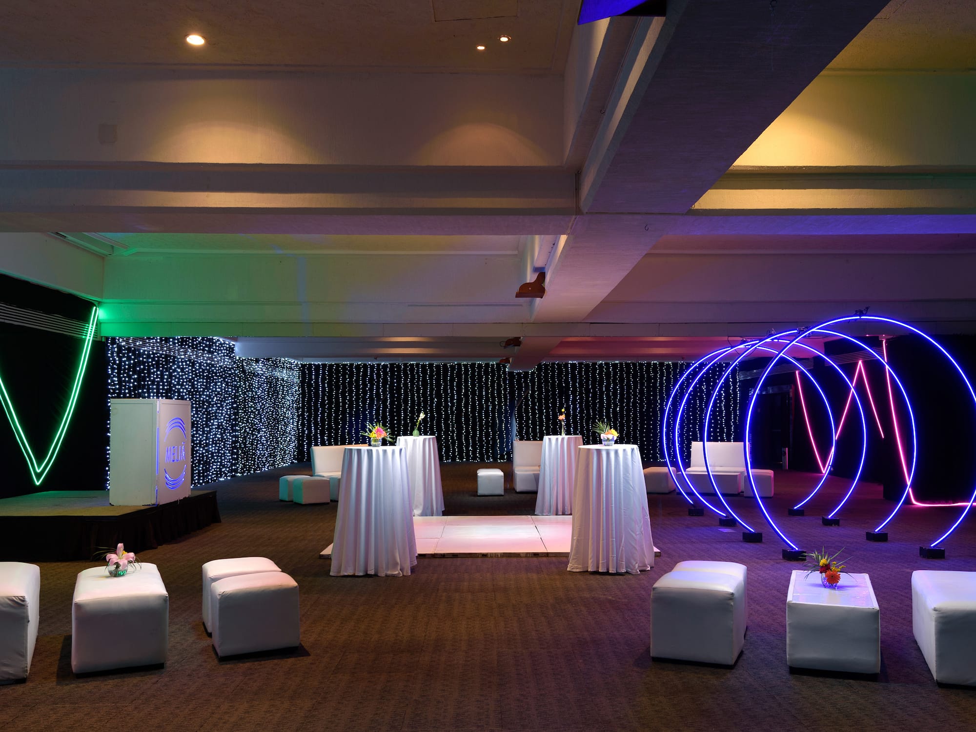 a room with white tables and blue lights