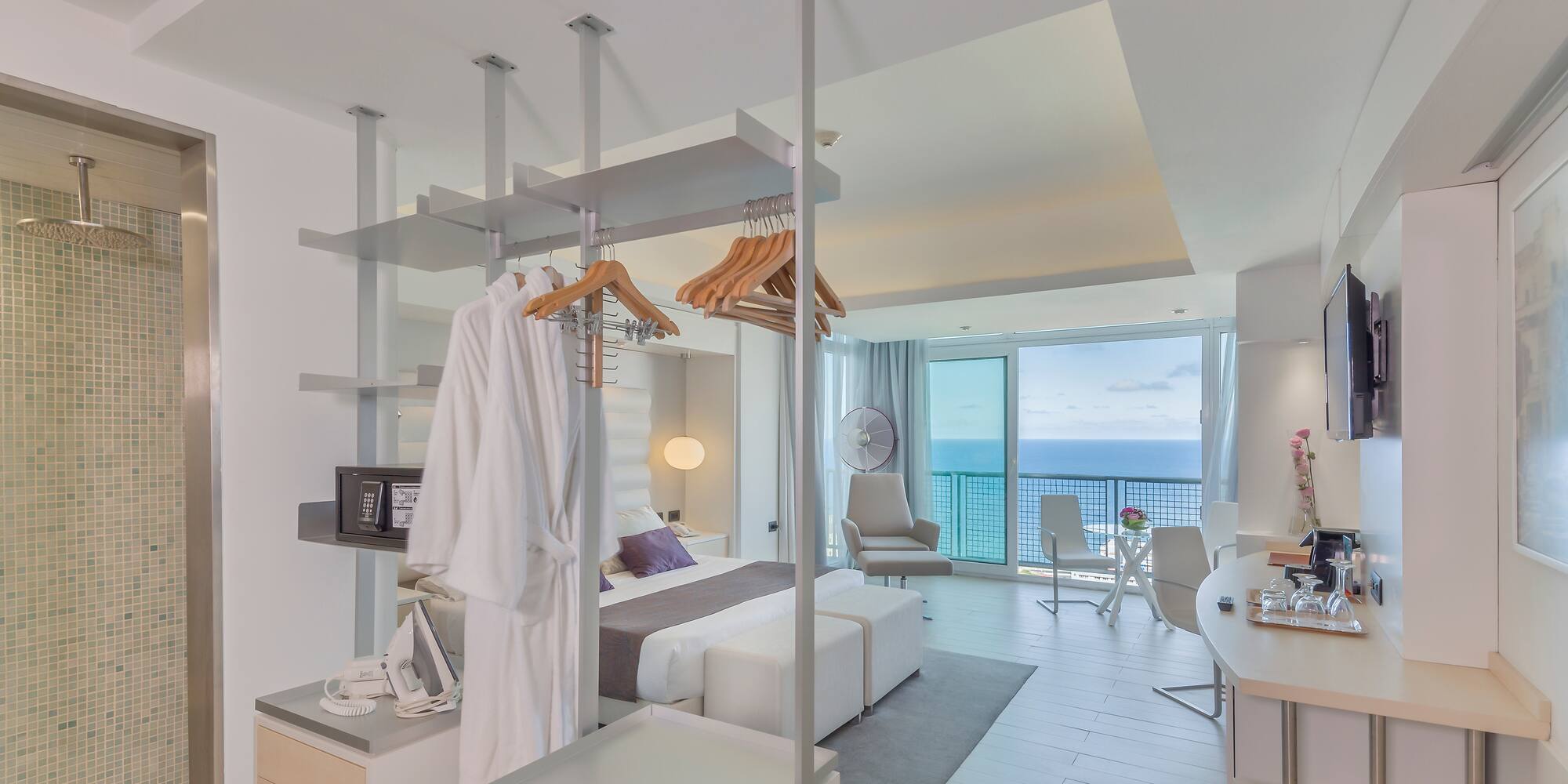 a room with a bed and a desk and chairs