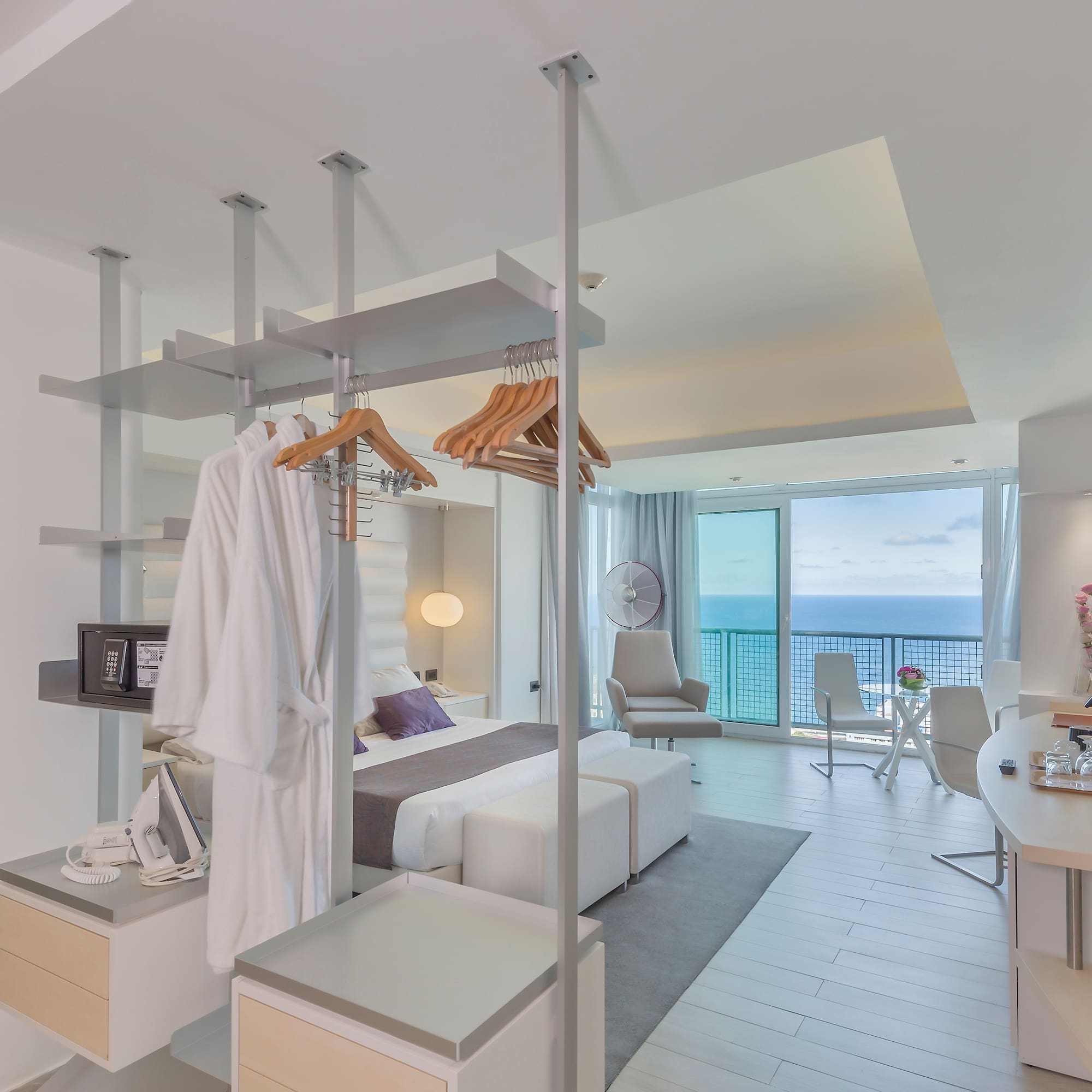 a room with a bed and a desk and chairs