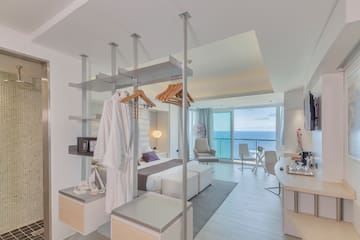 a room with a bed and a desk and chairs