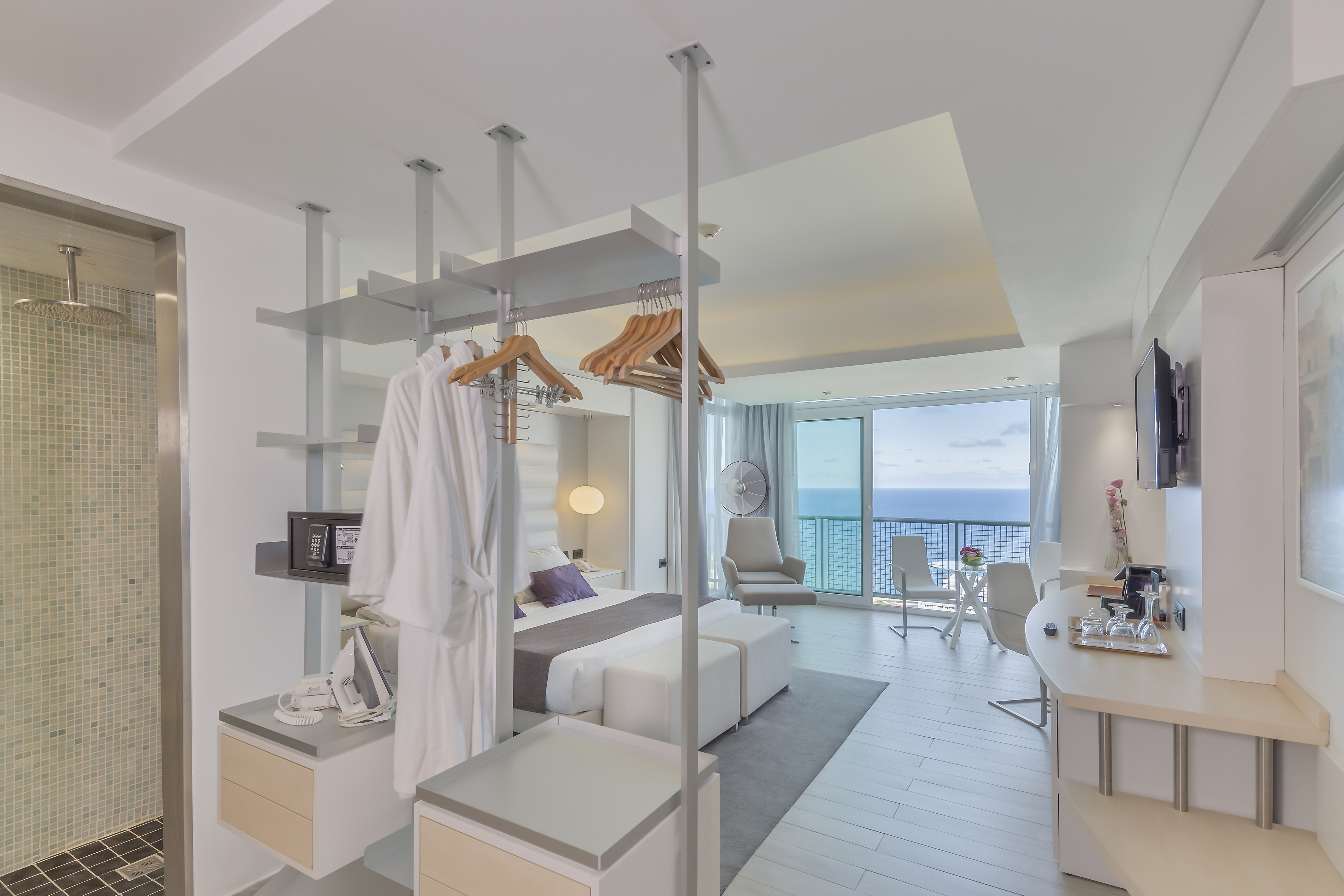 a room with a bed and a desk and chairs