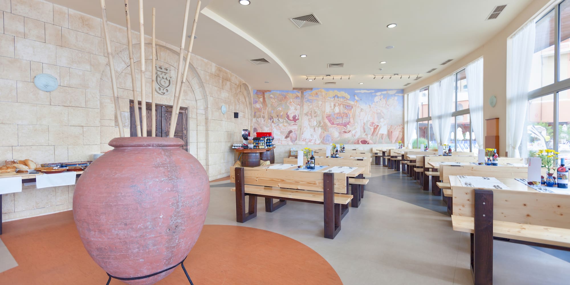 a room with tables and chairs and a large vase