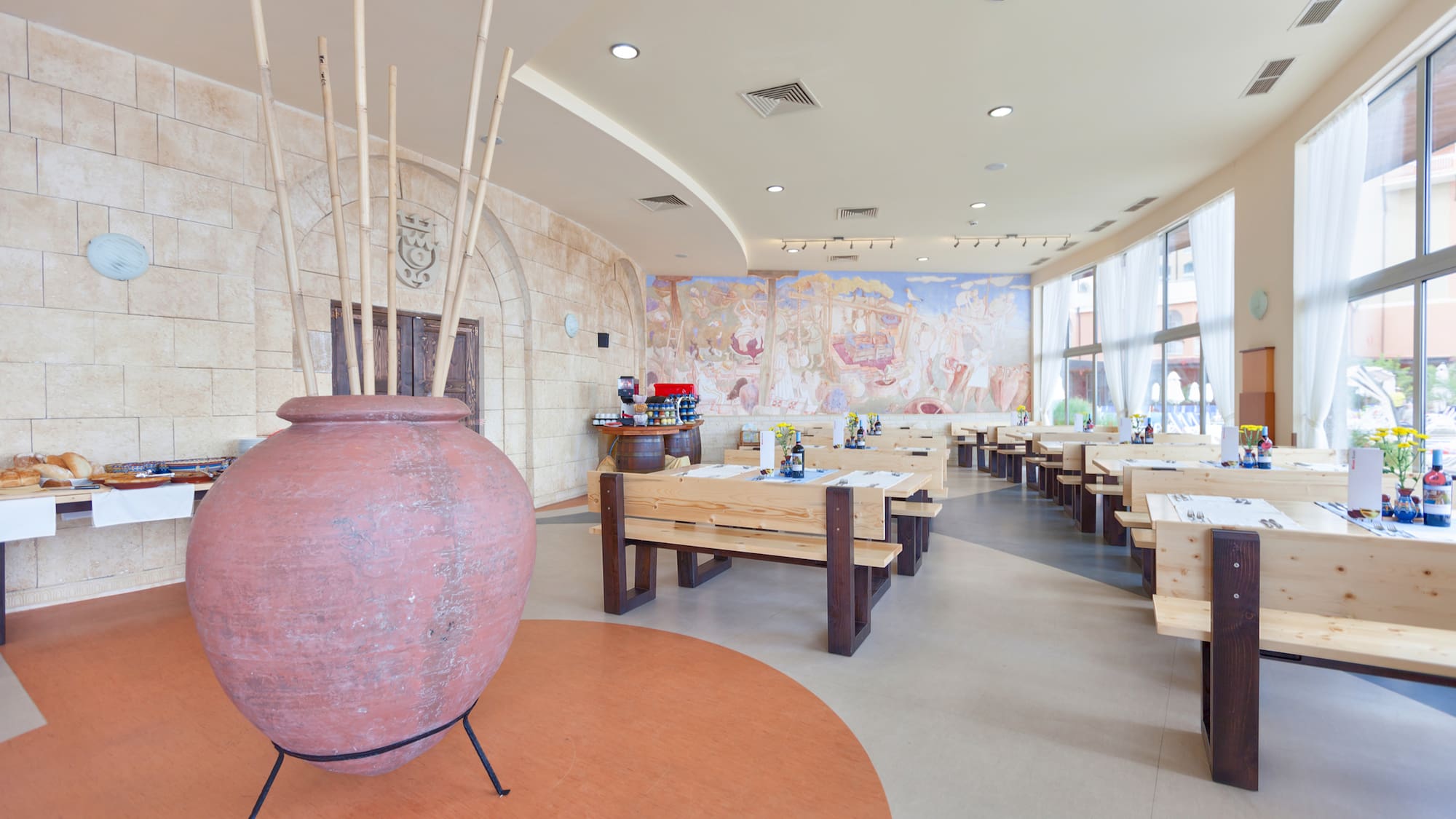 a room with tables and chairs and a large vase