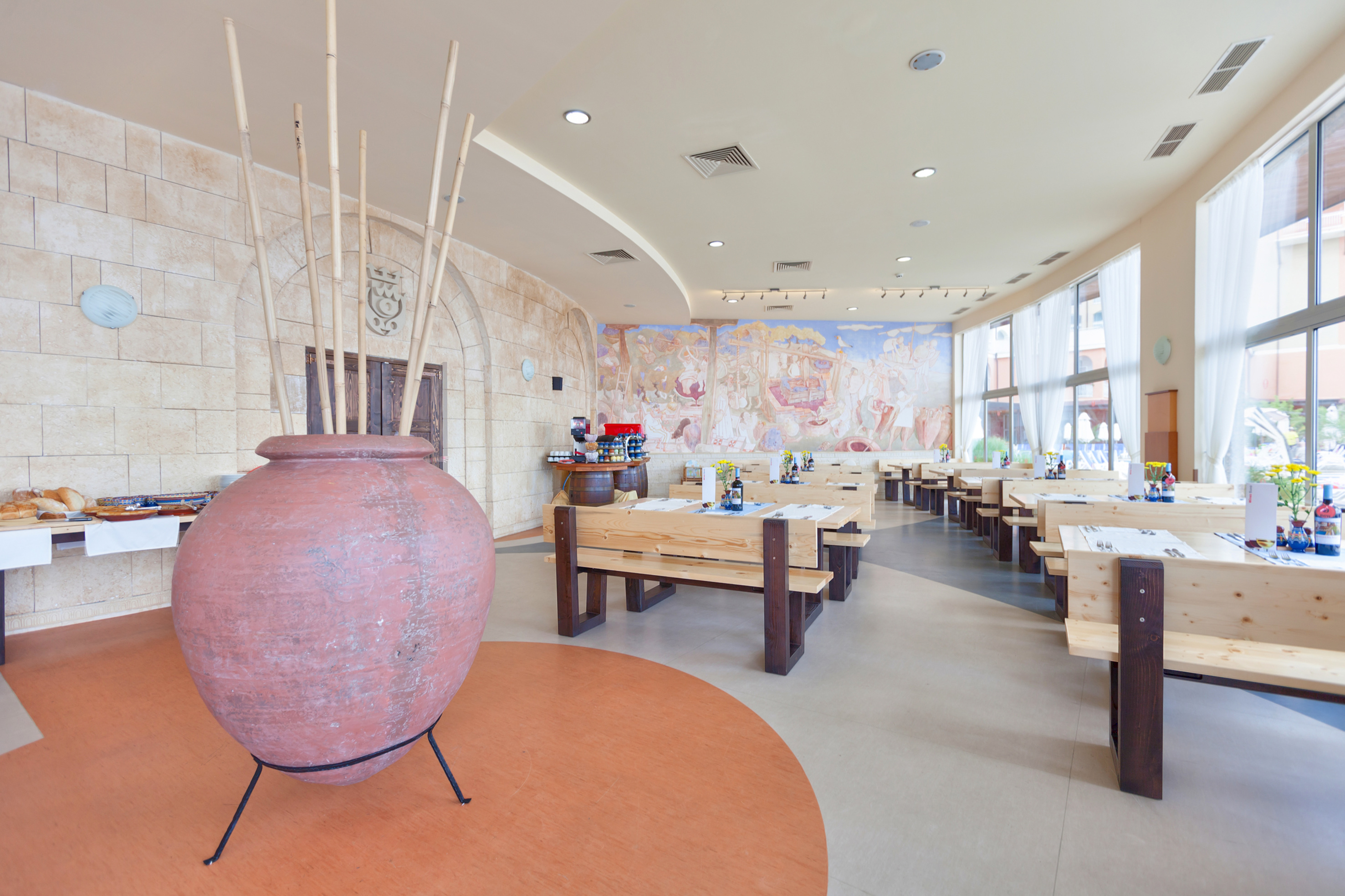 a room with tables and chairs and a large vase