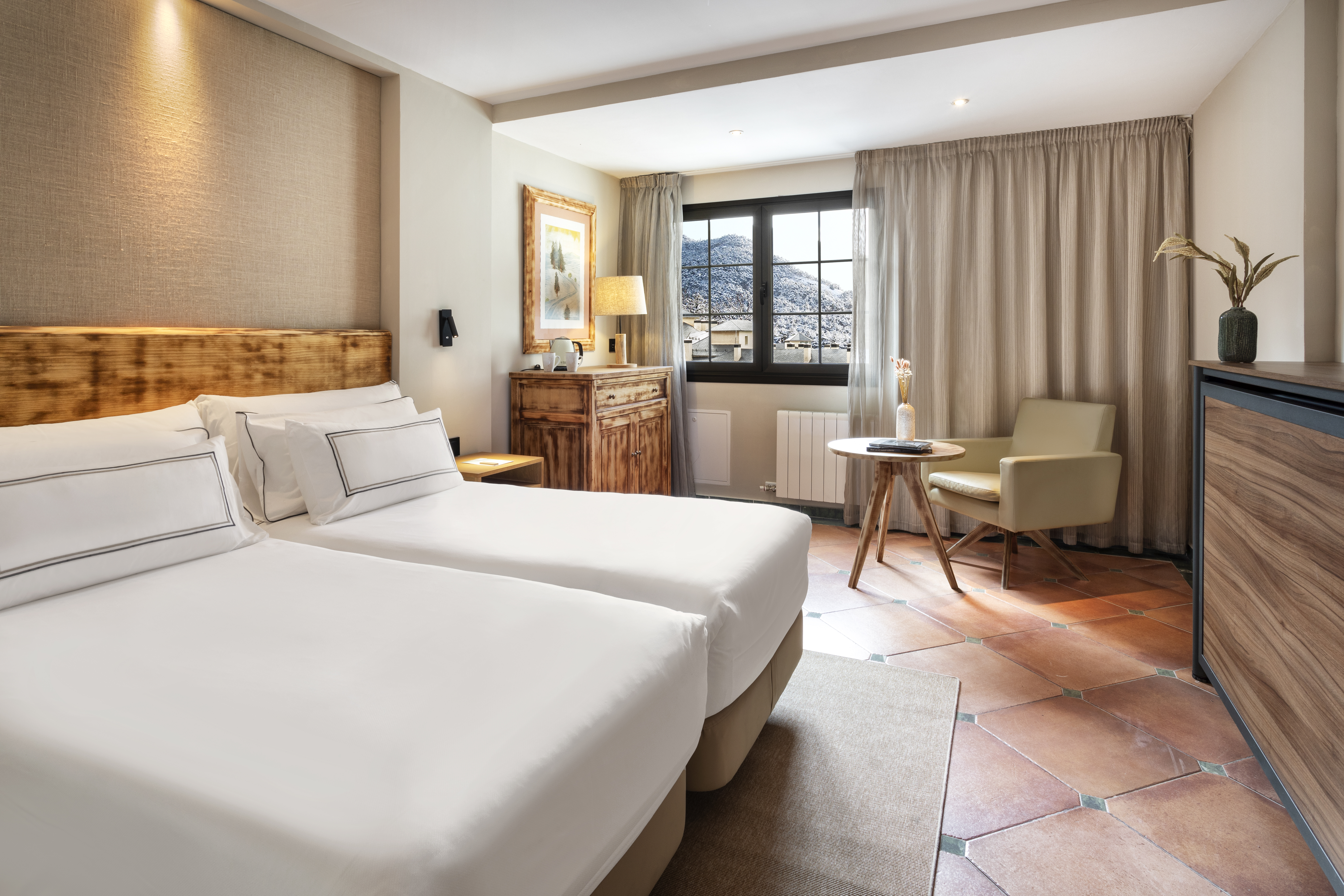 a room with two beds and a chair