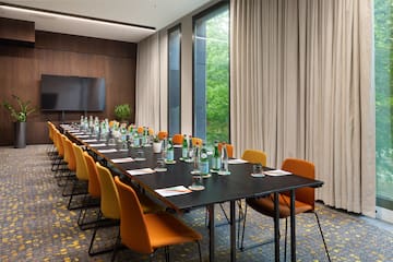 a long conference table with bottles of water and chairs