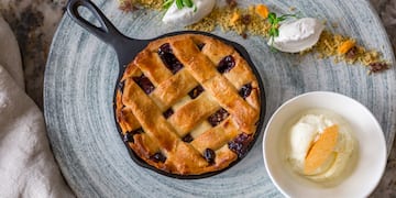 a pie in a skillet next to a bowl of ice cream