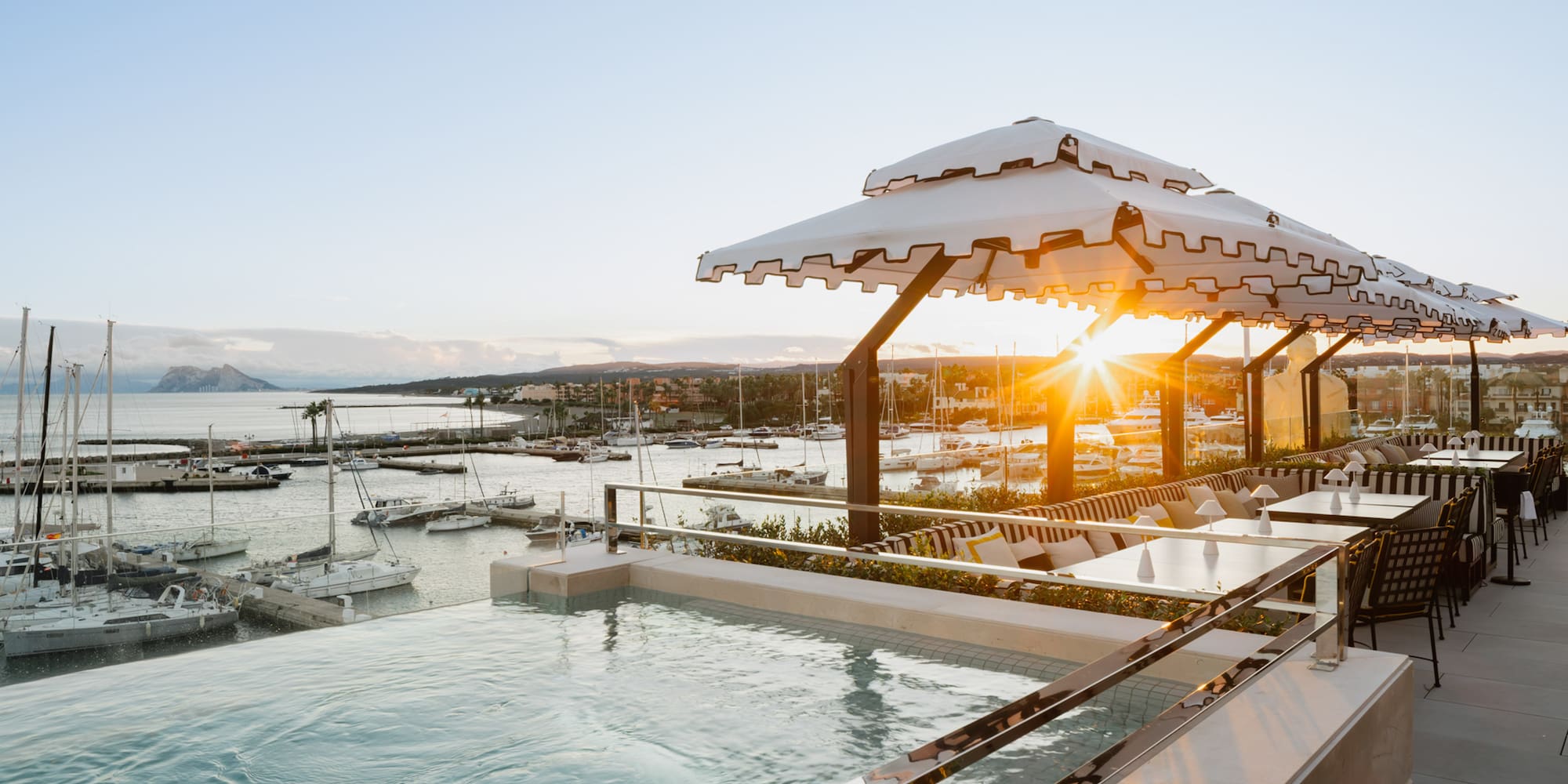 a pool with a view of a marina and boats in the background
