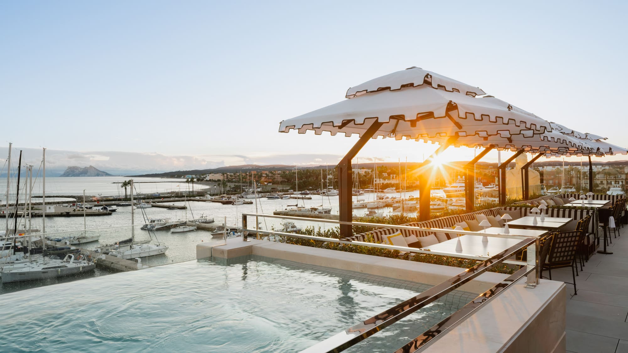 a pool with a view of a marina and boats in the background