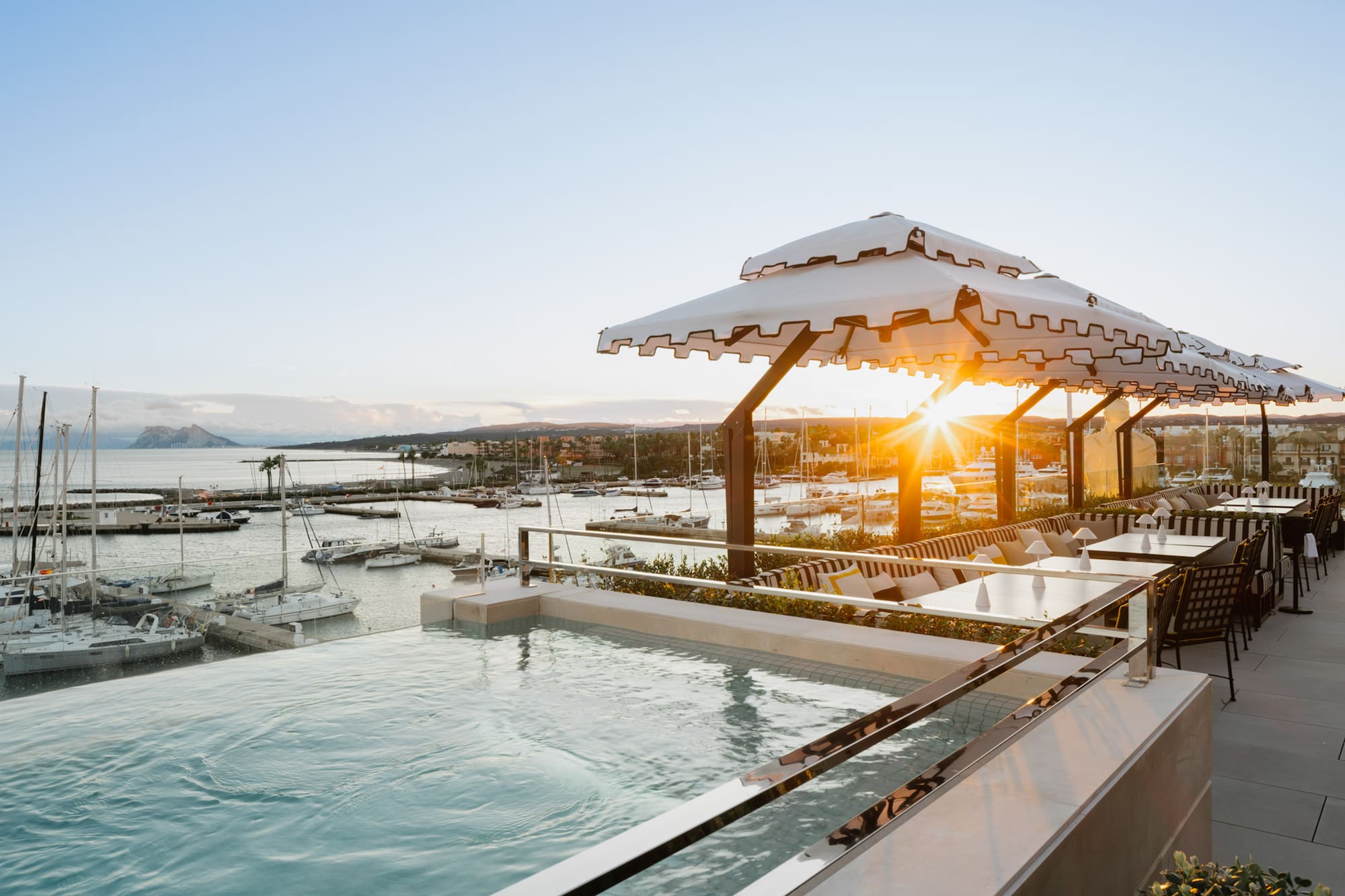 a pool with a view of a marina and boats in the background