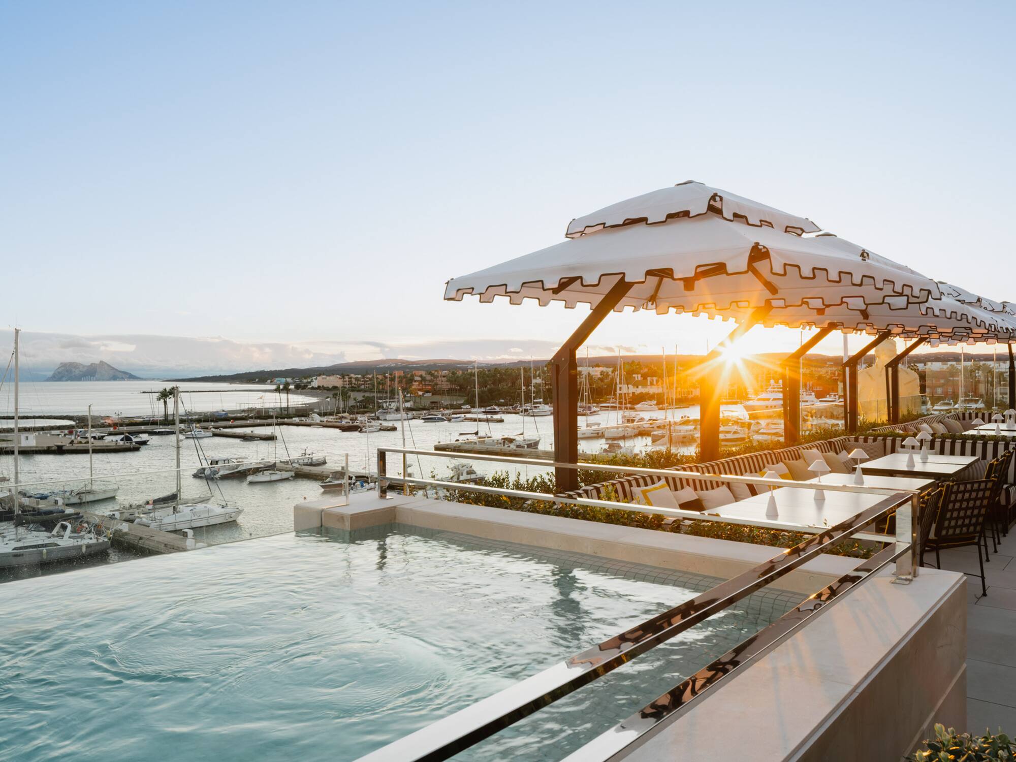 a pool with a view of a marina and boats in the background