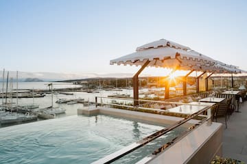 a pool with a view of a marina and boats in the background