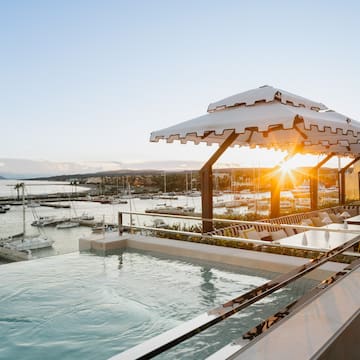 a pool with a view of a marina and boats in the background