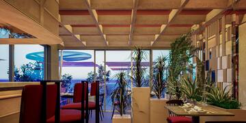 a room with a table and chairs and plants