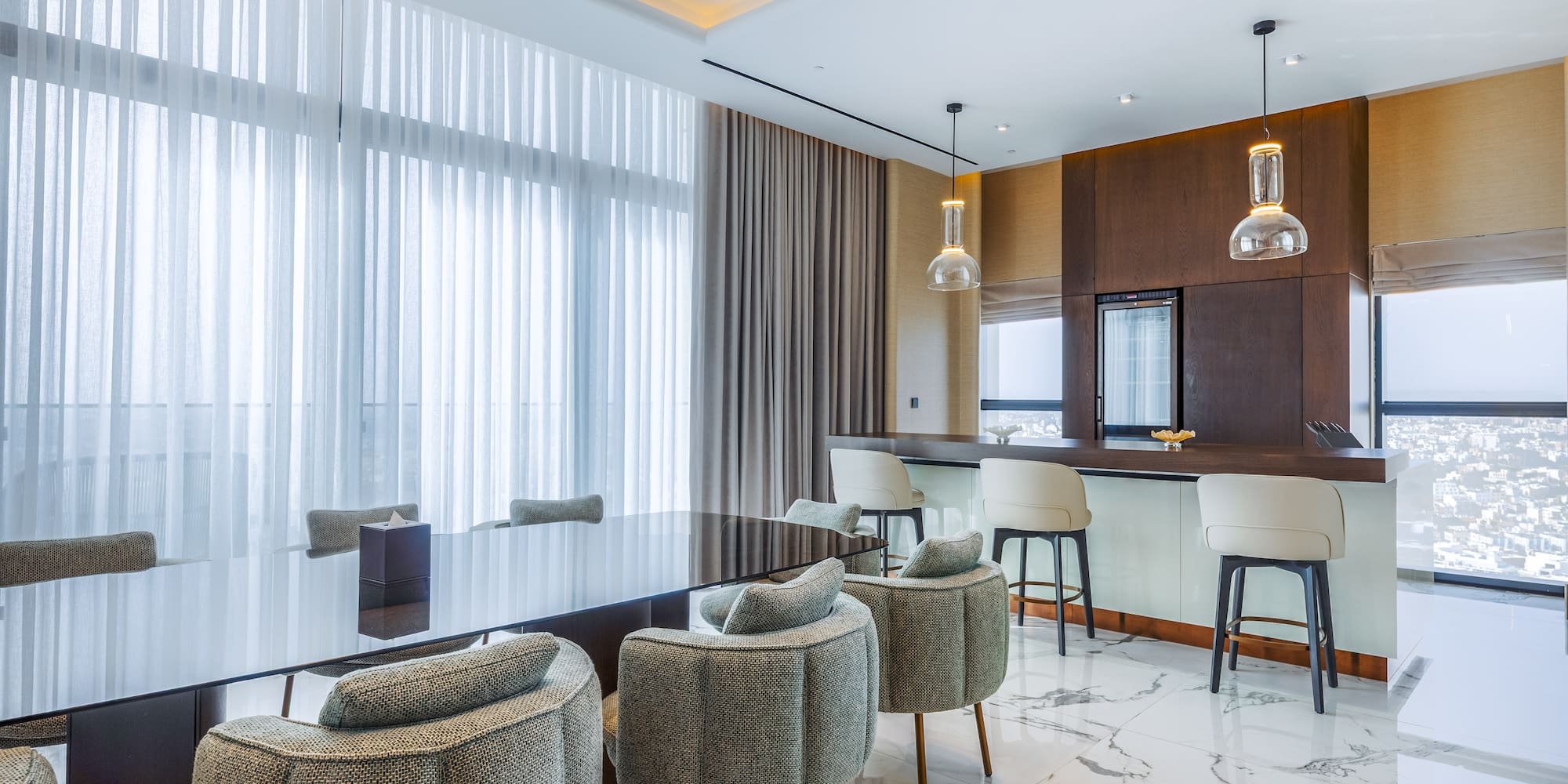 Luxury modern dining room with bar, dark table, stylish chairs, and city view.