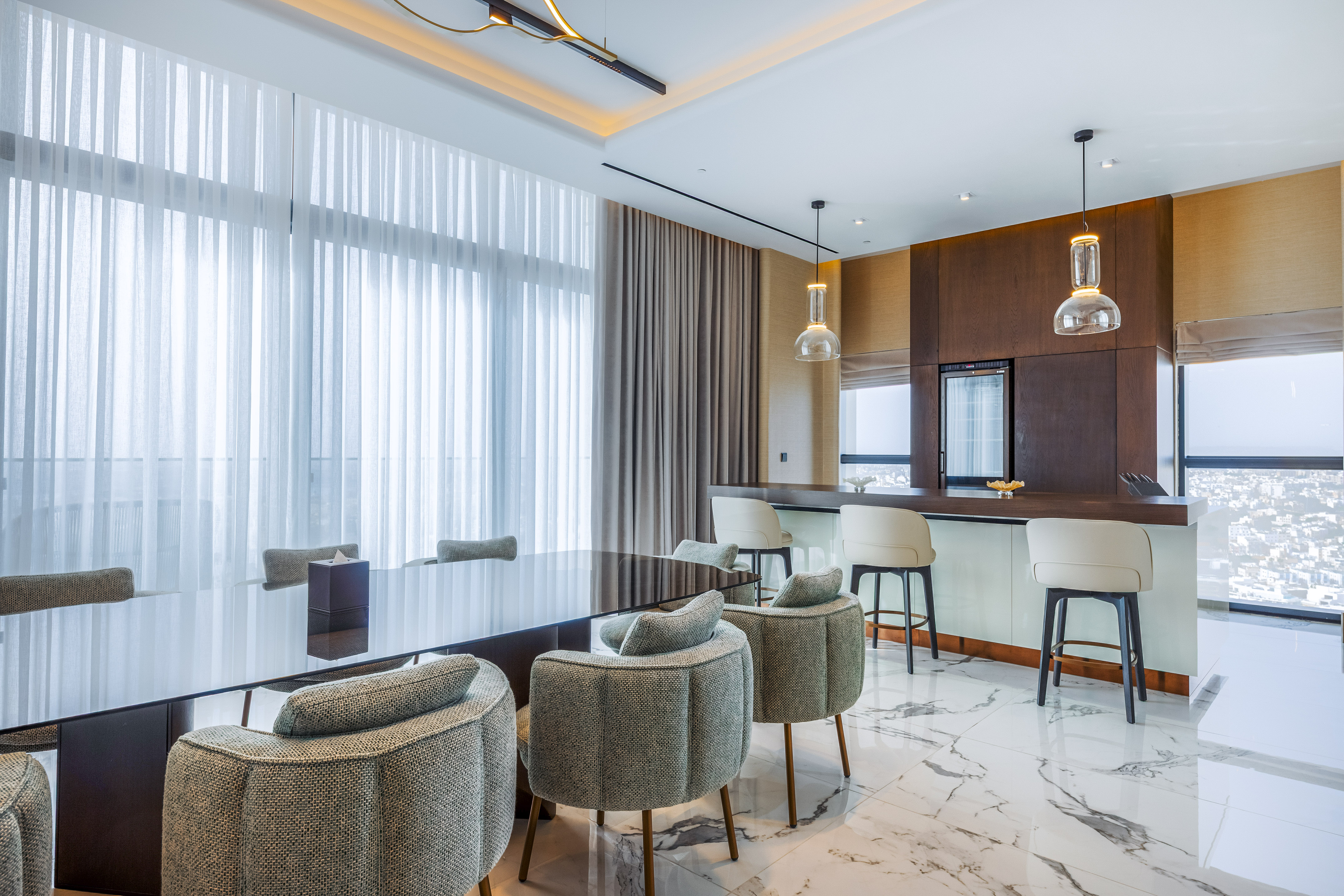 Luxury modern dining room with bar, dark table, stylish chairs, and city view.