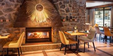 a room with a fireplace and a table and chairs