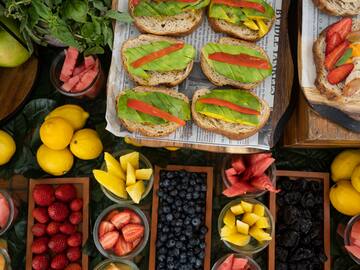 a table with different fruits and sandwiches