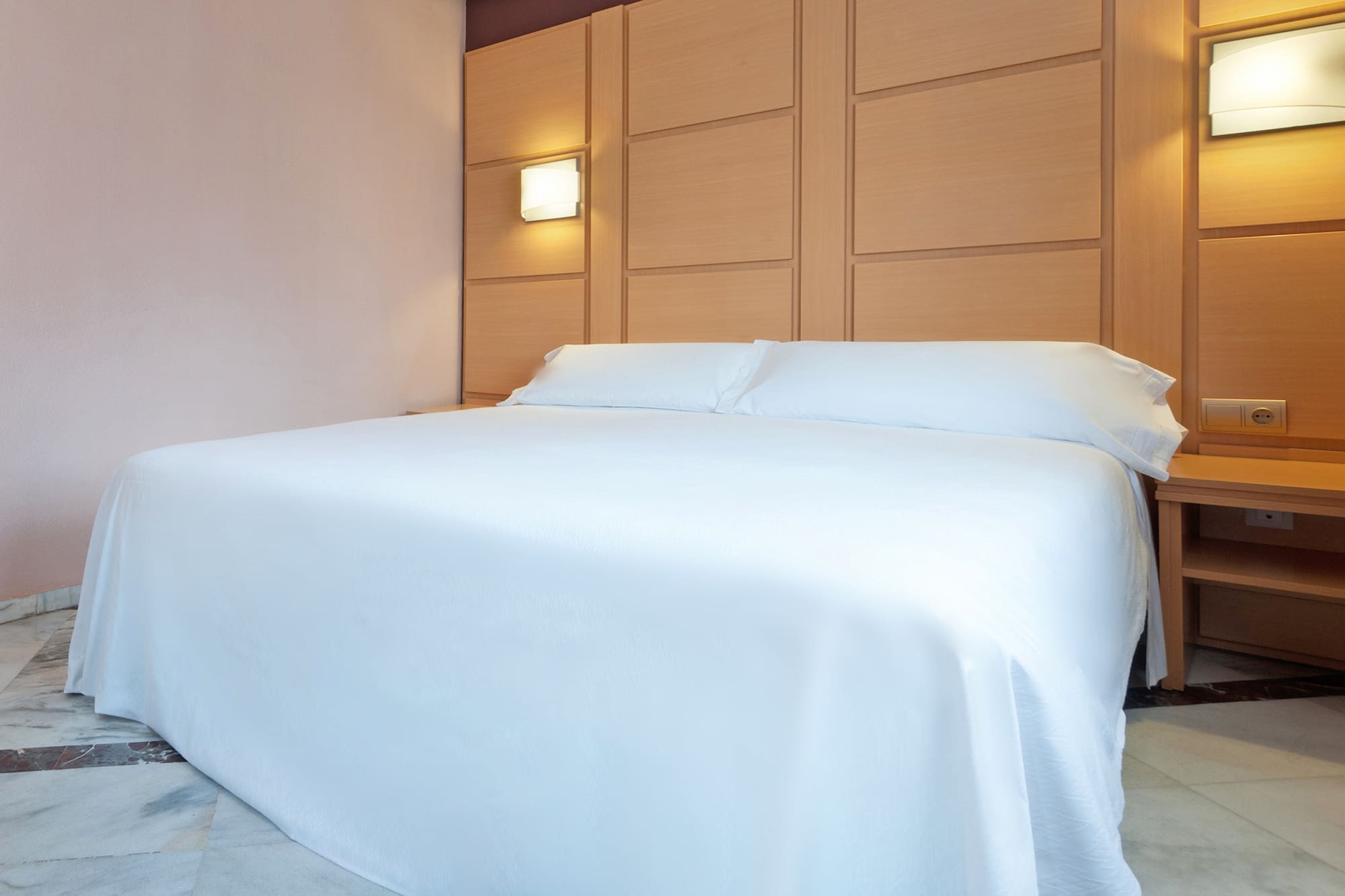 a bed with a white sheet and pillows