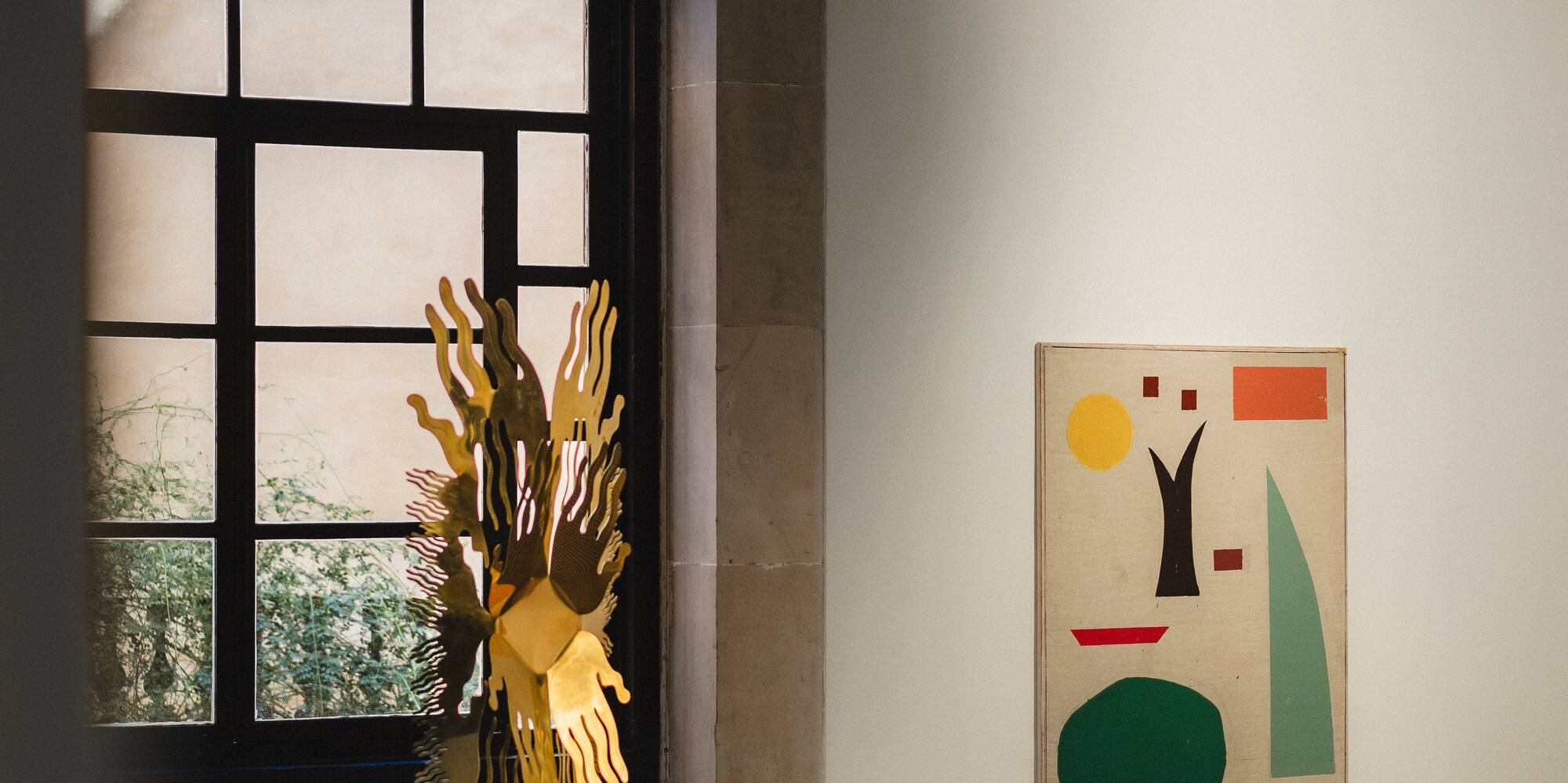 a sculpture on a pedestal in a room with a window