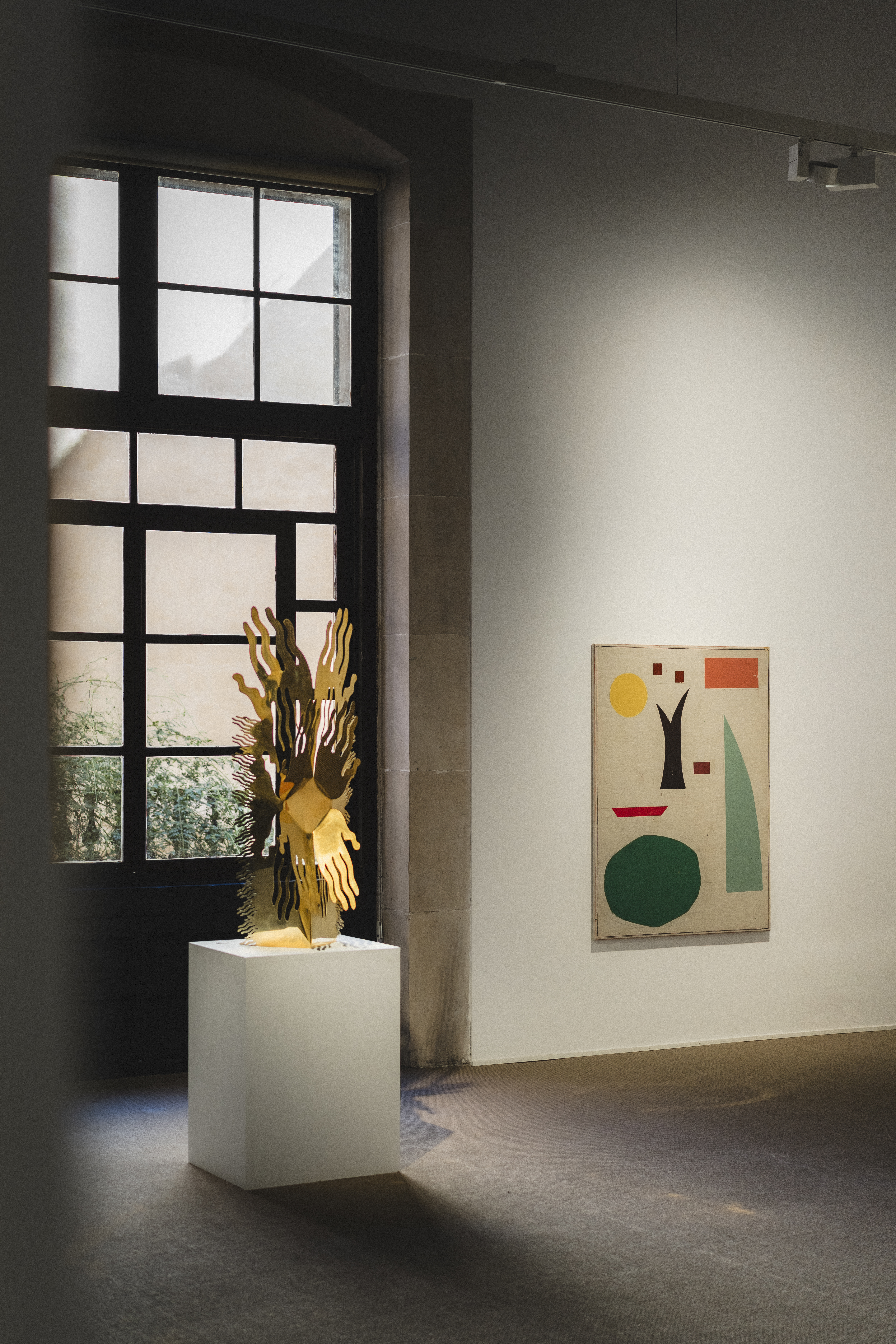 a sculpture on a pedestal in a room with a window