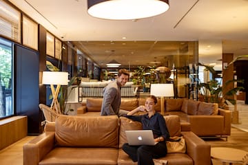a man and woman sitting on a couch with a laptop