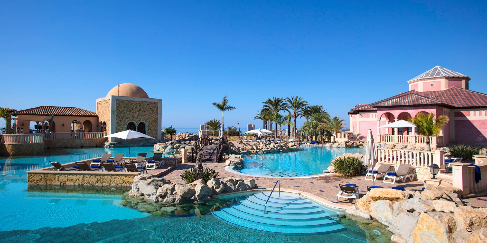 a pool with a stone building and a dome roof