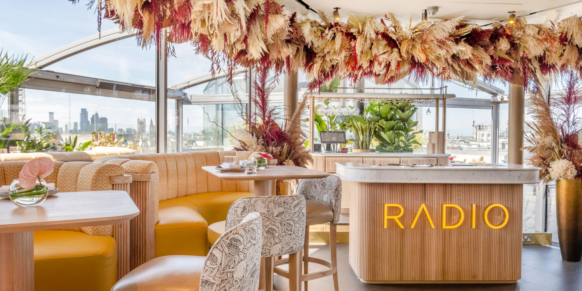 a room with tables and chairs and a bar with a large window