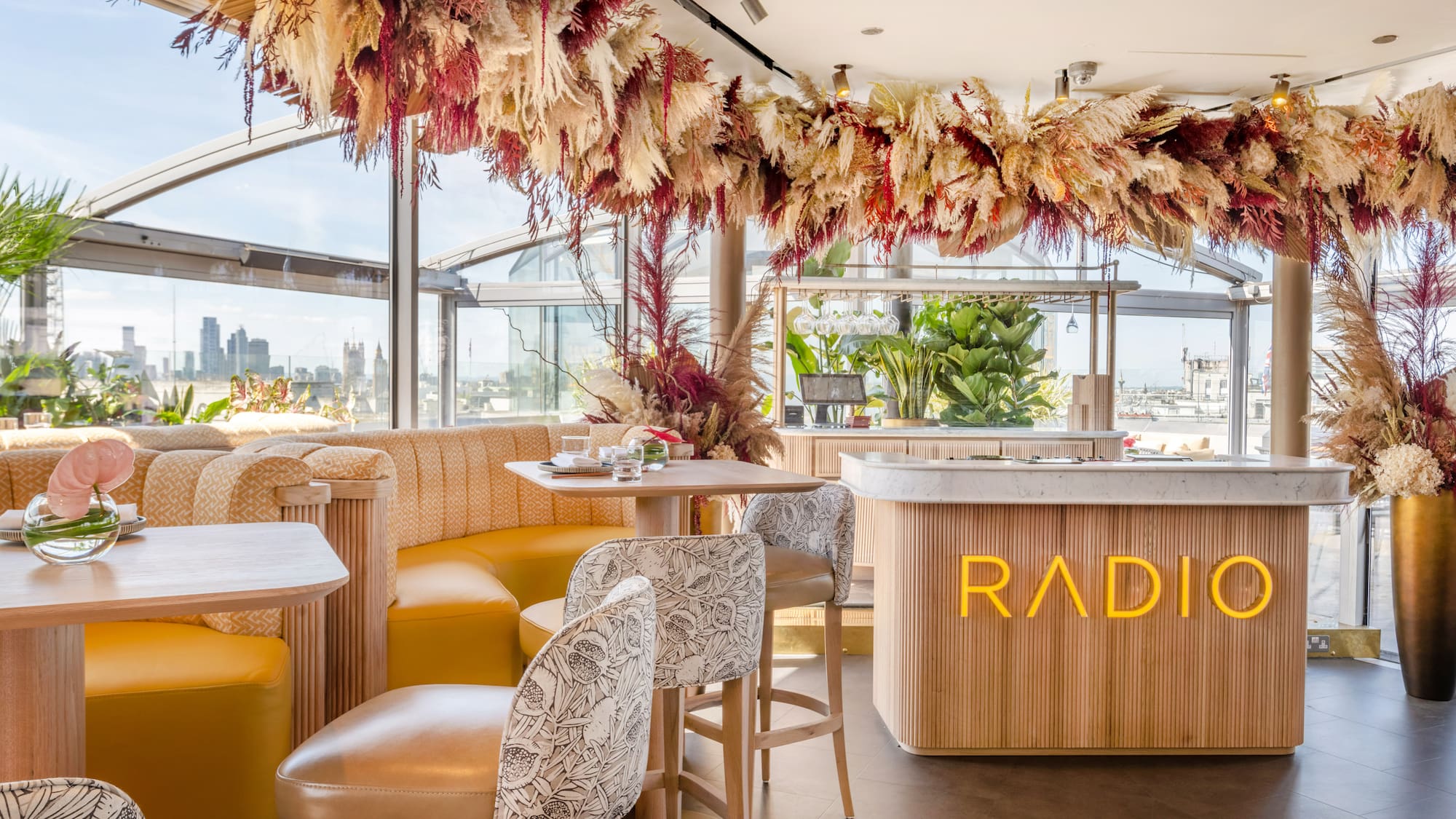 a room with tables and chairs and a bar with a large window