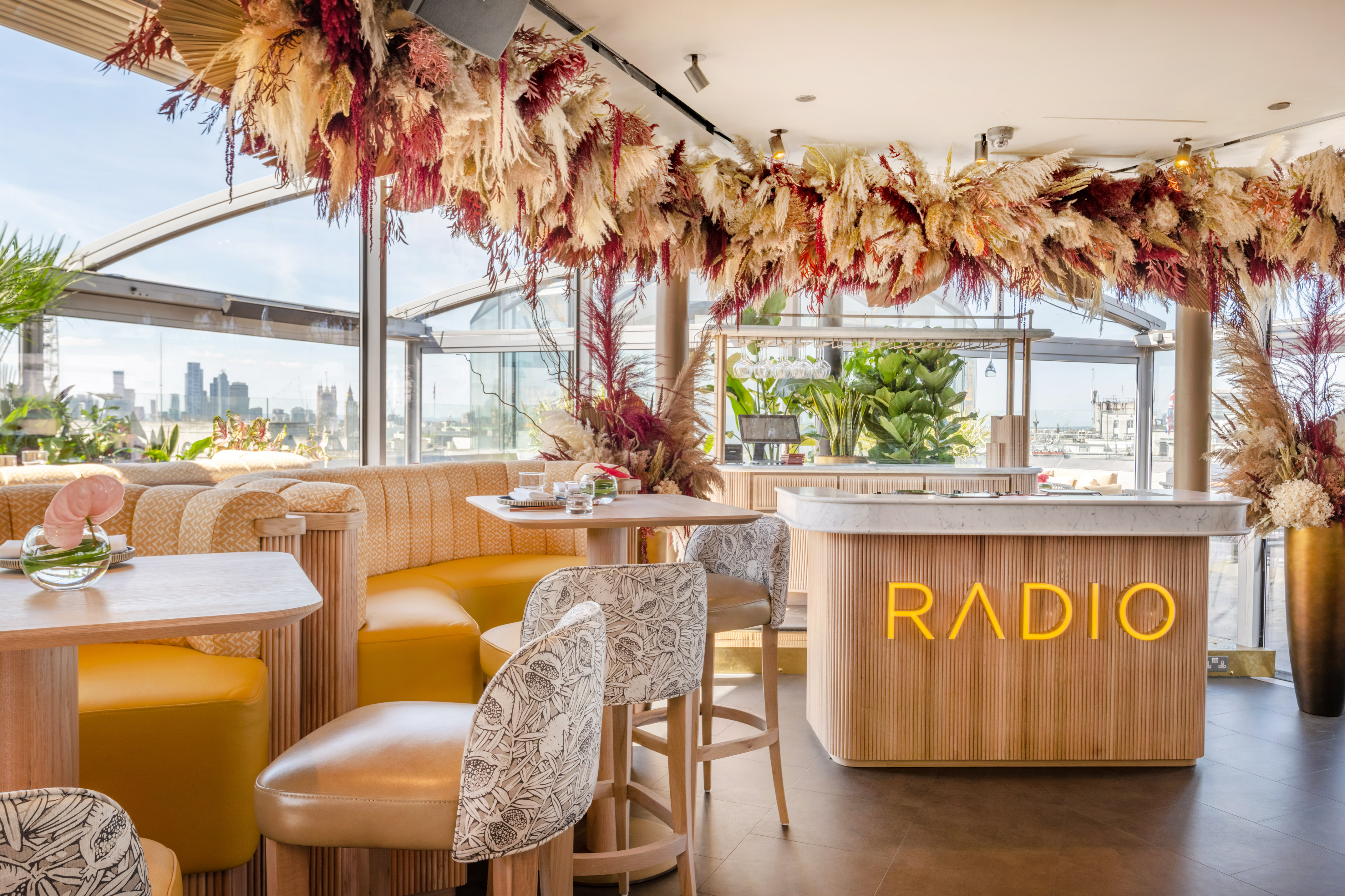 RADIO luxury rooftop bar interior with London skyline and dried floral ceiling.