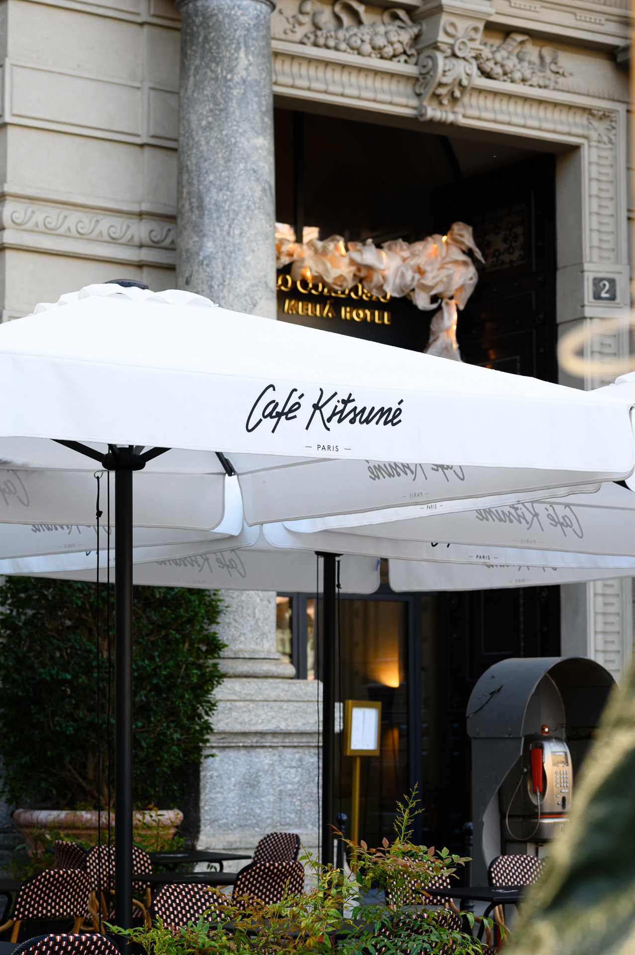 White Café Kitsuné Paris umbrella over outdoor cafe seating.