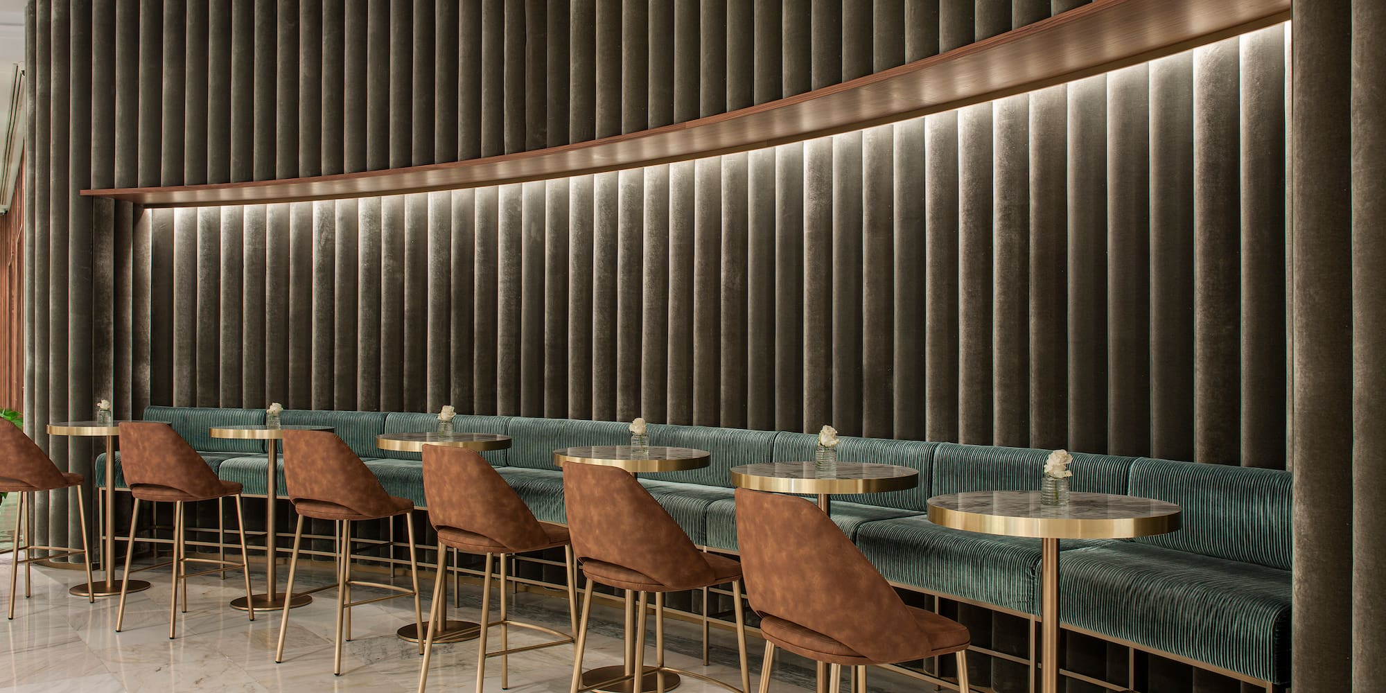 a room with a row of tables and chairs