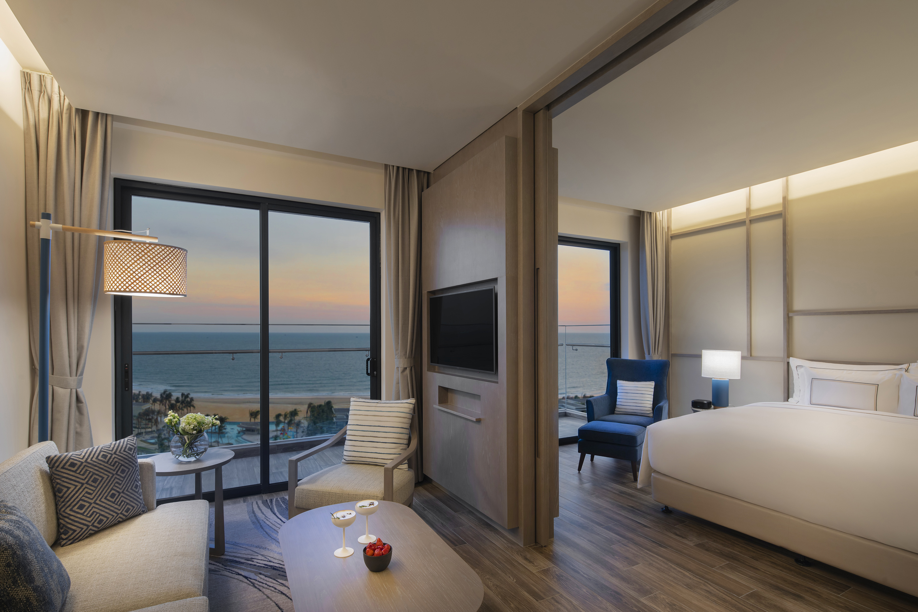 Beachfront hotel suite with ocean view, living room, and bedroom.