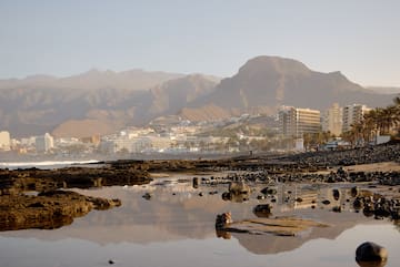 a rocky beach with mountains in the background