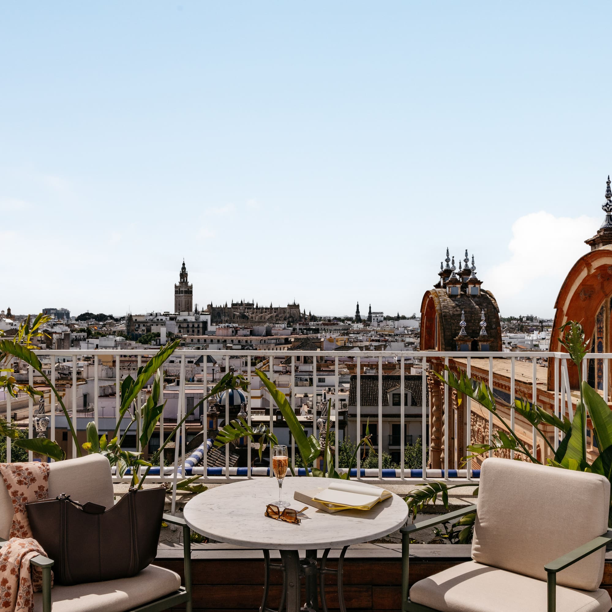 Azotea en Sevilla con vistas a la Giralda. Mesa, copa y libro.