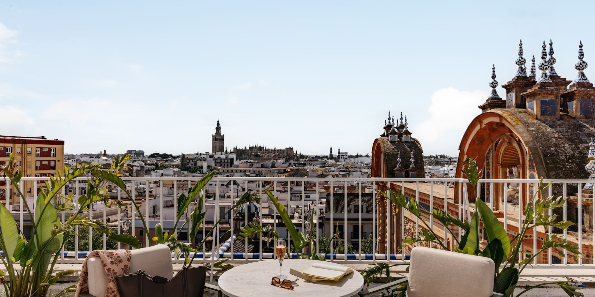 Azotea en Sevilla con vistas a la Giralda. Mesa, copa y libro.
