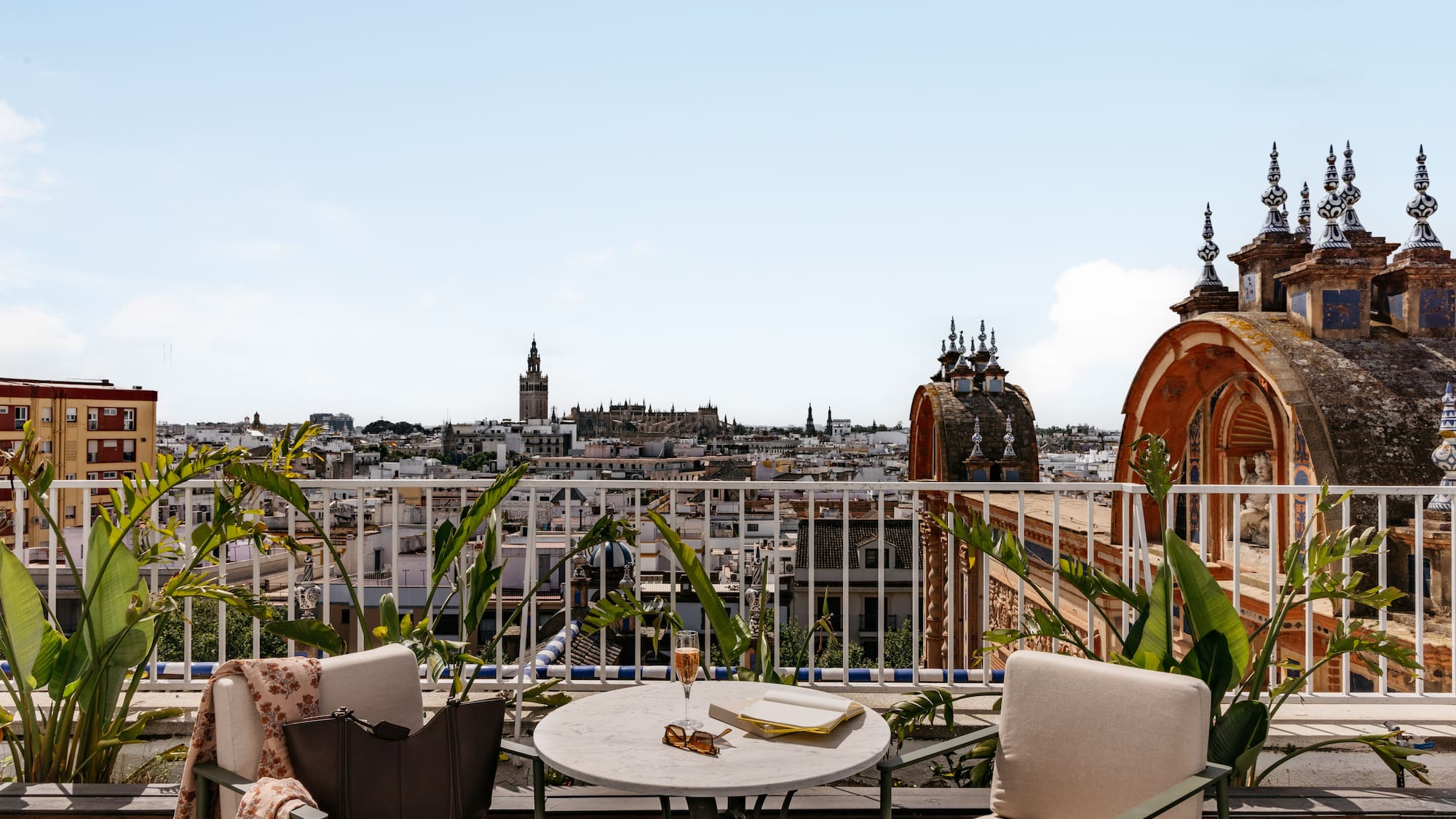 Azotea en Sevilla con vistas a la Giralda. Mesa, copa y libro.